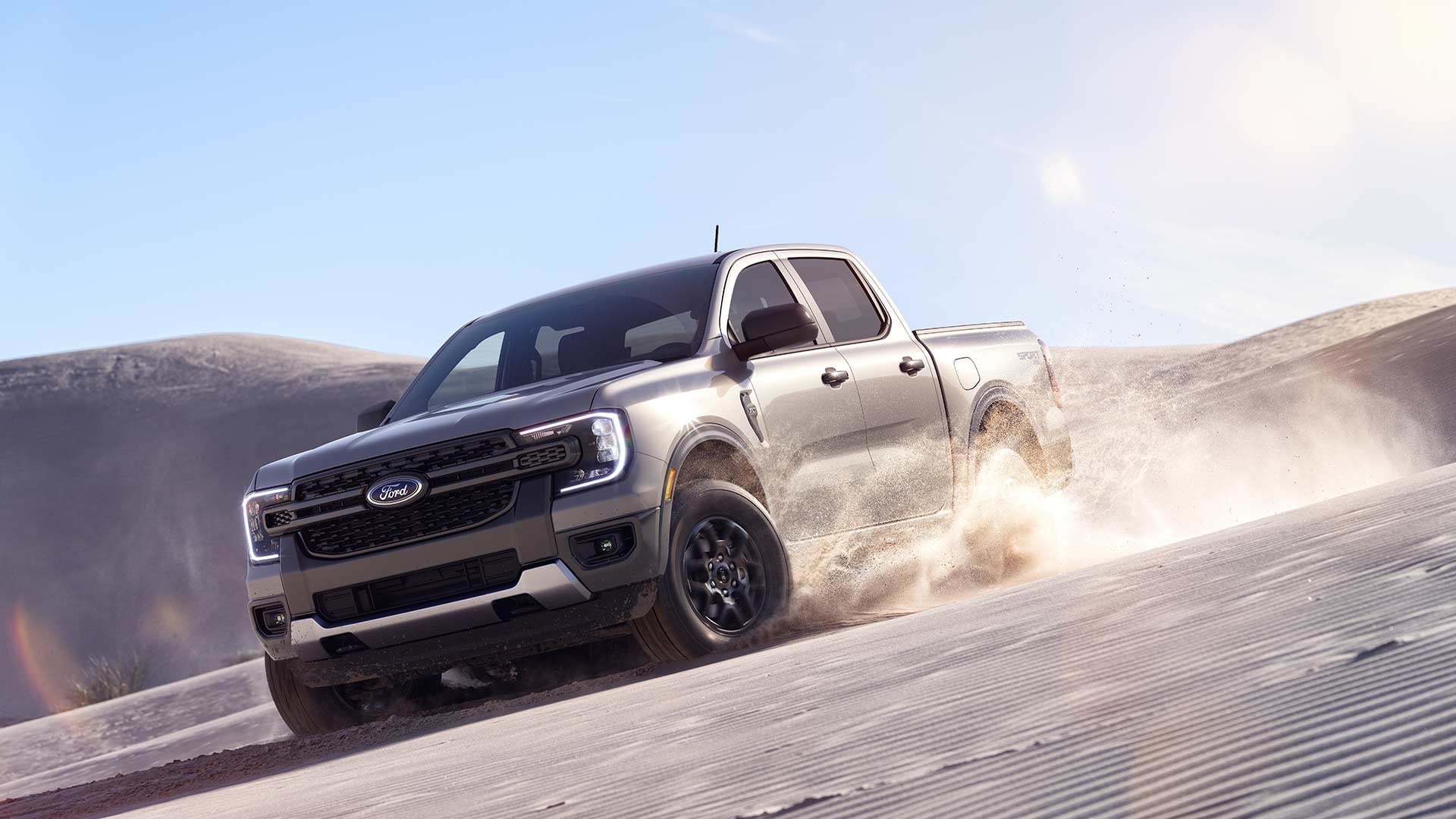 Ford Ranger kicking up sand on a desert trail, the kind of driving that adds lease-end wear for Santa Fe, NM Ford lease drivers