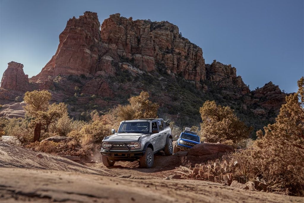 Ford Bronco on a red dirt trail below rock mesas in the high desert near Santa Fe, New Mexico
